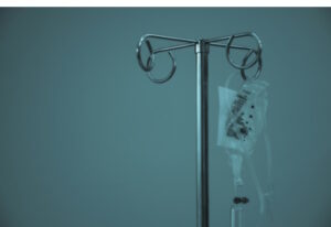 An intravenous drip bas hanging on a IV stand.
