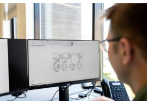 Engineer looking at technical industrial drawing on computer screen